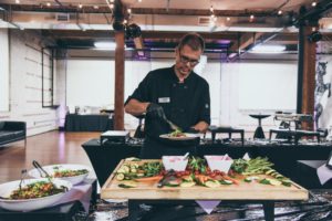 A man standing in front of a table with food on it.