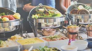 A buffet table with food and drinks on it.